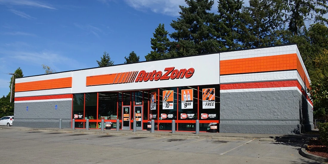 The front of an AutoZone auto parts store with its orange and red sign and glass storefront