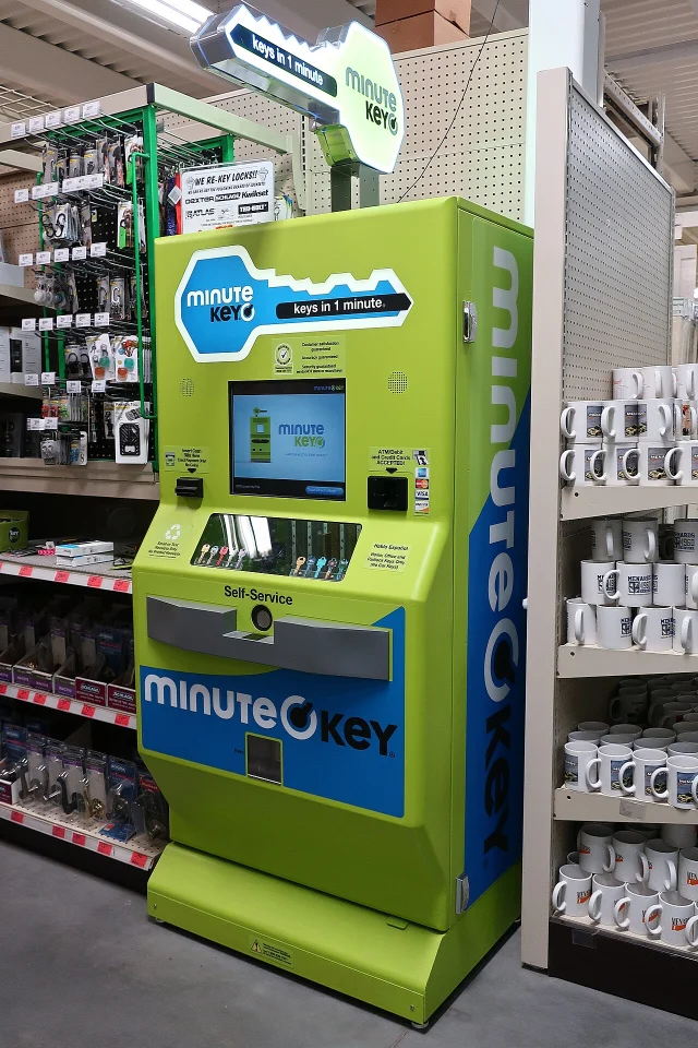 A green Minute Key self-service key copy kiosk standing in a home improvement store aisle