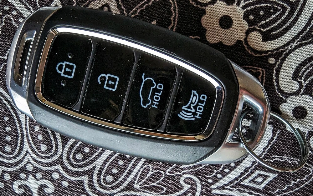 A Hyundai smart key fob with lock, unlock, trunk, and panic buttons resting on a cloth